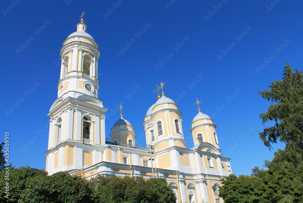 Orthodox church surrounded by green trees in blue sky background