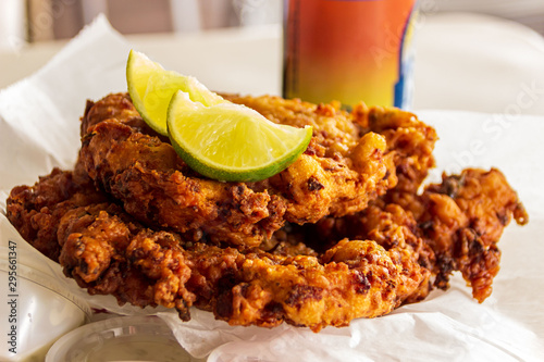 Two delicious conch fritters with sliced limes served as an appetizer. photo