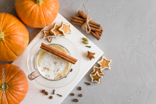Pumpkin spice latte in a glass on a gray background. Top view, copy space. Selective focus.