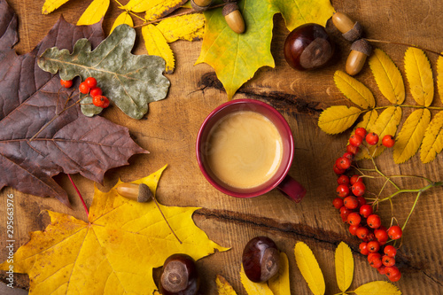 Autumn, fall leaves, hot steaming cup of coffee on wooden table background. Sunday morning coffee relaxing and still life concept. Top view.