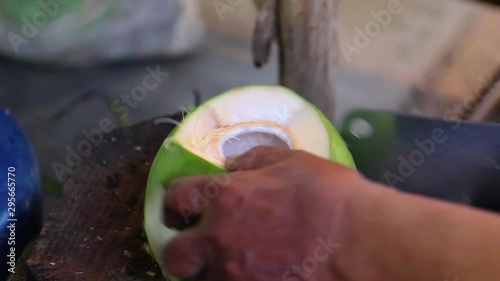 Portrait of the man peeling coconut in Thailand street food market.