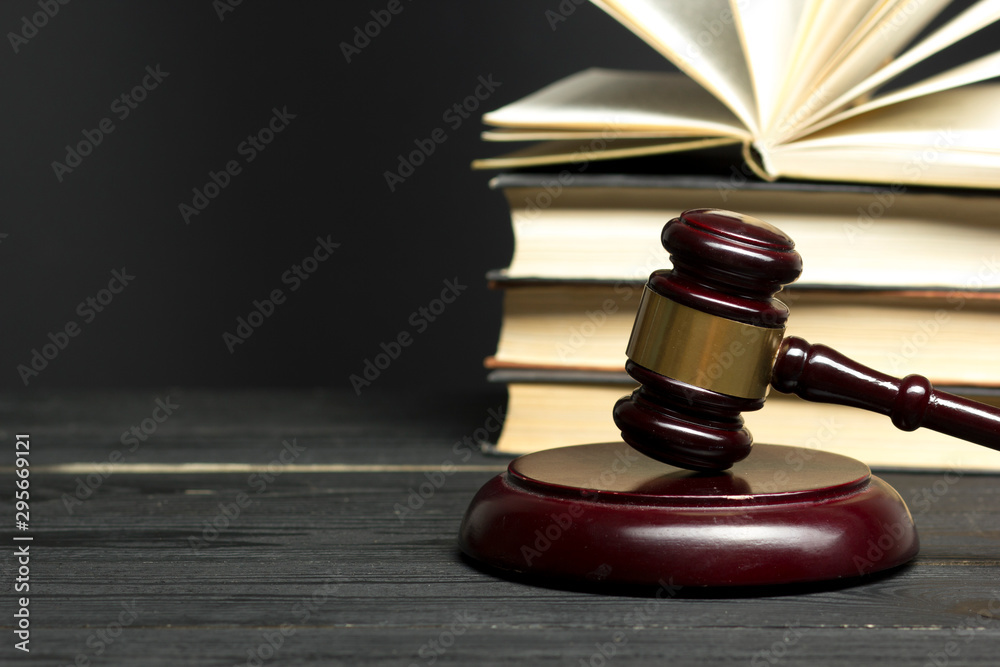Law concept - Open law book with a wooden judges gavel on table in a courtroom or law enforcement office isolated on white background. Copy space for text. Law concept - Open law book with a wooden judges gavel on table in a courtroom or law enforcement office isolated on white background. Copy space for text.