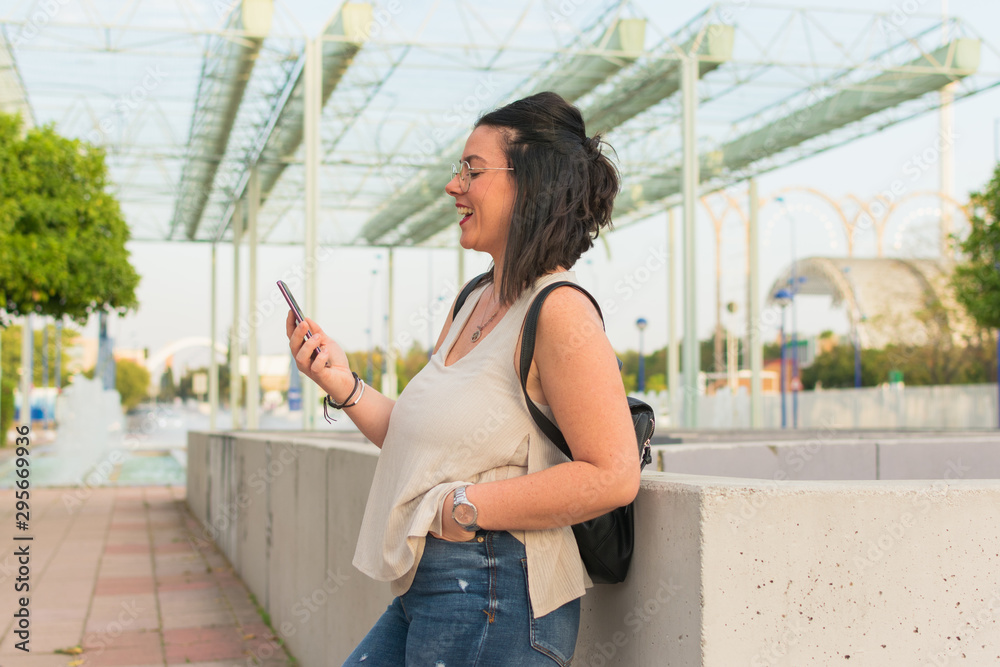 woman wearing her cell phone while smiling woman wearing her cell phone while smiling