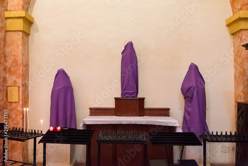 des statues chrétiennes catholiques sont sous un drap voile pourpre pour le vendredi saint et carême  de la semaine sainte photo