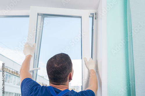 the master installs a part of the window in a new plastic frame, rear view