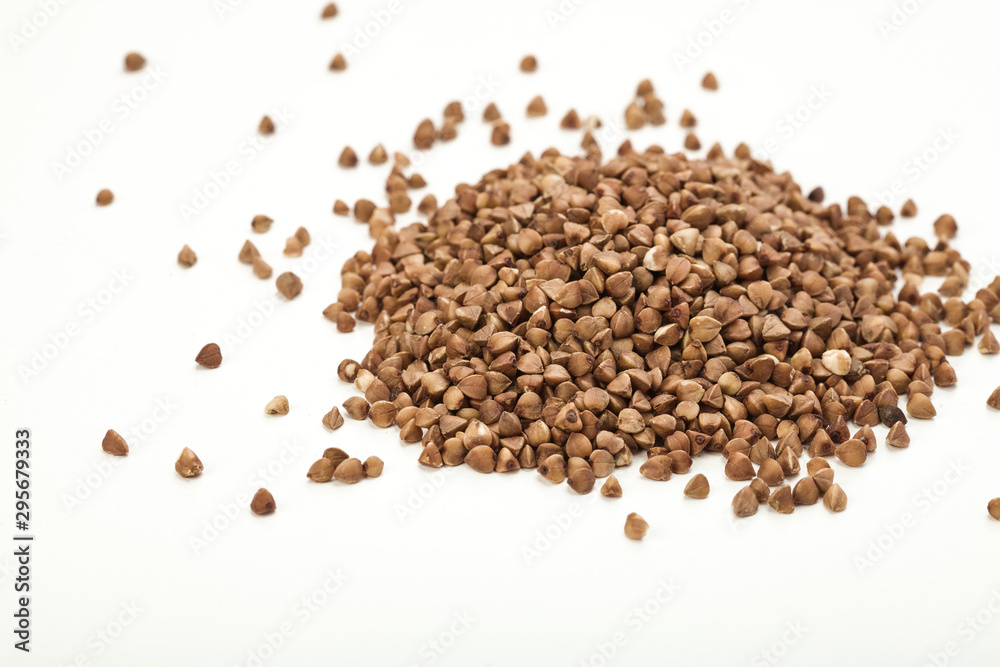 handful of buckwheat on a white table handful of buckwheat on a white table