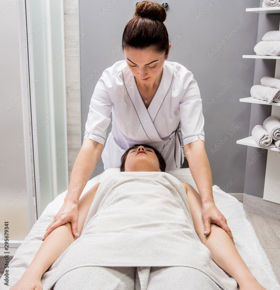 Beautiful young woman enjoying massage in spa salon. Cosmetology