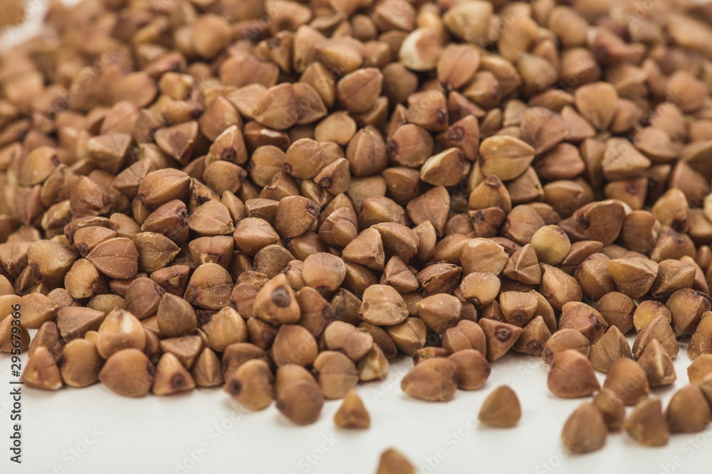 handful of buckwheat on a white table handful of buckwheat on a white table