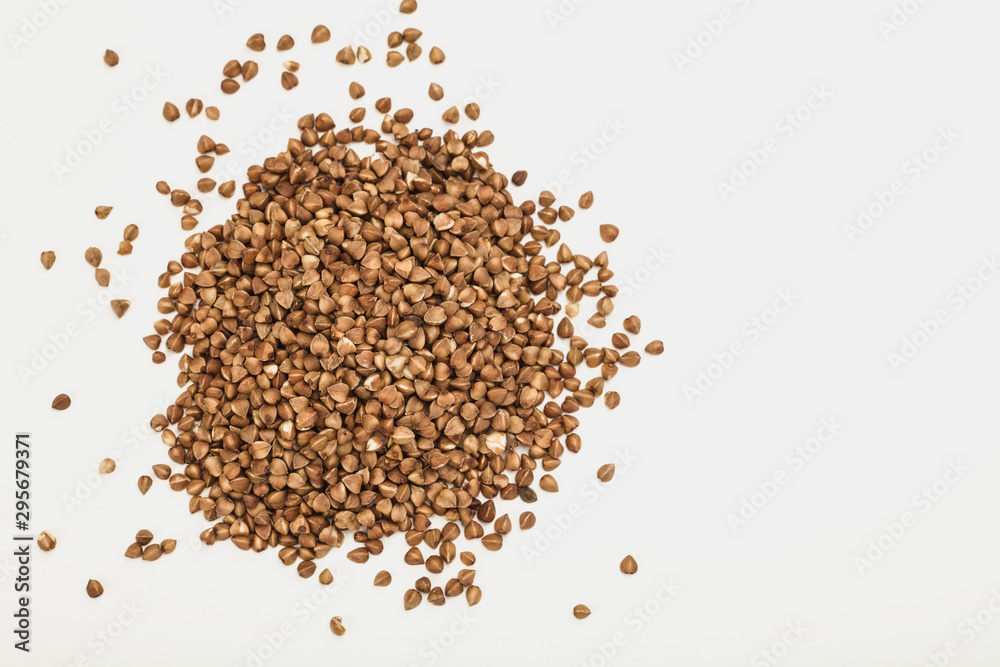 handful of buckwheat on a white table handful of buckwheat on a white table