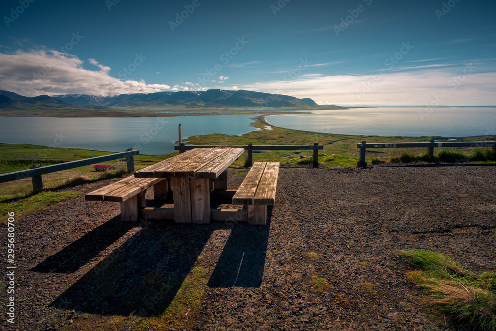 Wooden bench on the ocean shore to mountain view