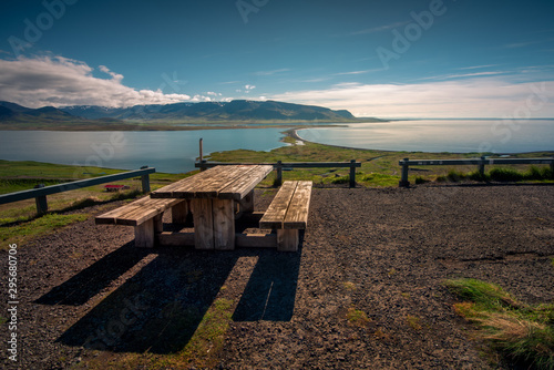 Obraz na płótnie Wooden bench on the ocean shore to mountain view w salonie