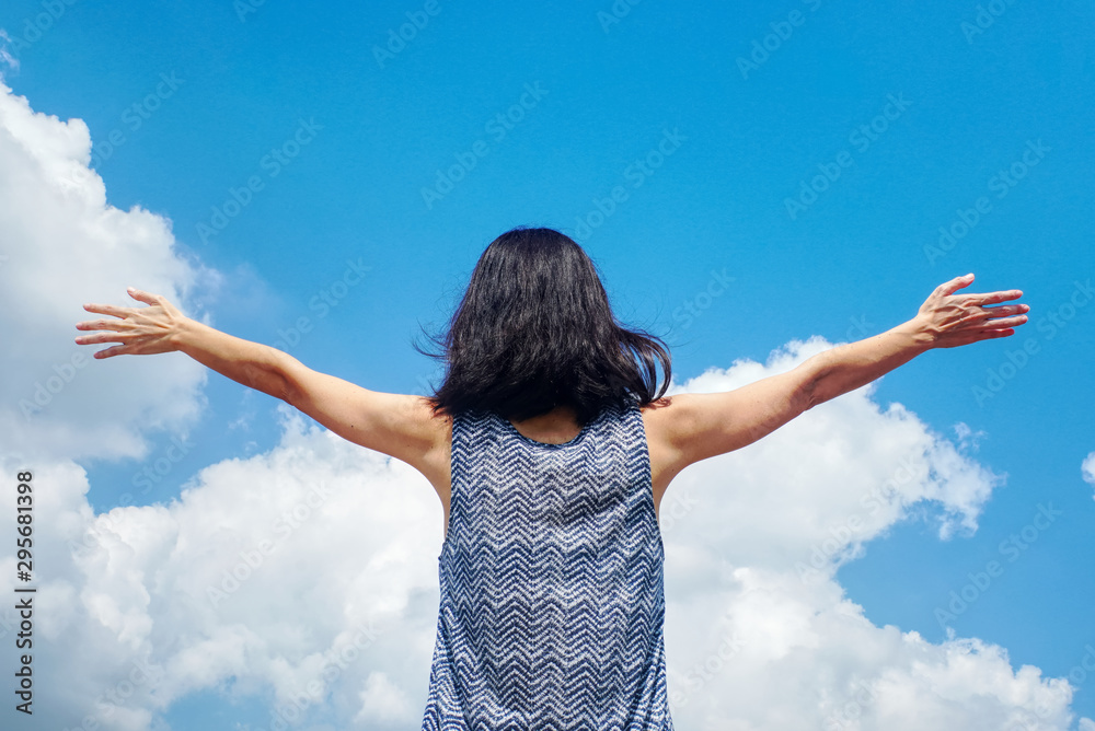 Cheerful woman open her arms with background blue sky. Cheerful woman open her arms with background blue sky.