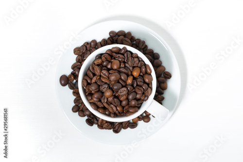 cup with coffee beans on white background, top view