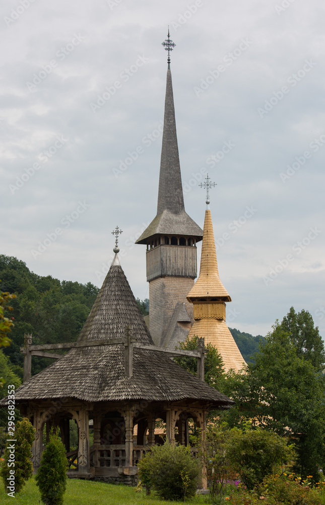 Fototapeta premium Panoramic view of traditional ancient Maramures wooden orthodox church in Transylvania with highest wooden belltower in Europe, Romania. UNESCO world heritage site.