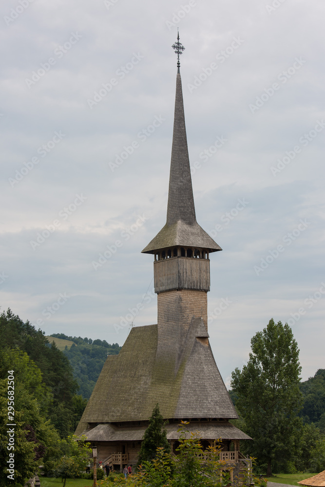 Panoramic view of traditional ancient Maramures wooden orthodox church in Transylvania with highest wooden belltower in Europe, Romania. UNESCO world heritage site. Panoramic view of traditional ancient Maramures wooden orthodox church in Transylvania with highest wooden belltower in Europe, Romania. UNESCO world heritage site.