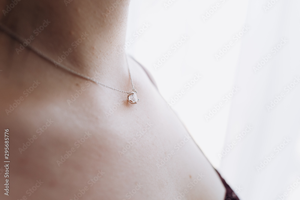 Girl with gold diamond pendant. Gold pendant with stone.