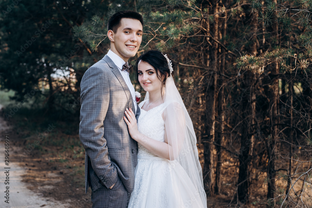 Wedding walk in the summer forest. Wedding photo shoot in summer. Newly married couple.