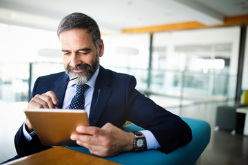 Elegant business multitasking multimedia man using devices