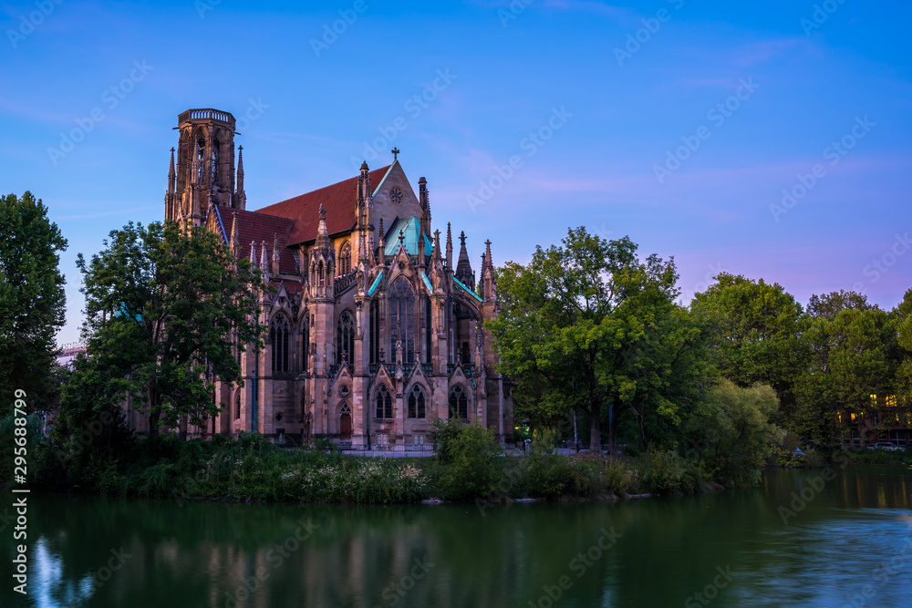 Germany, Beautiful ancient feuersee cathedral in downtown stuttgart city surrounded by lake water called church of st john after sunset with green trees