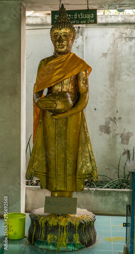 Bang Saen, Thailand - March 16, 2019: Wang Saensuk Buddhist Monastery. Gilded Buddha Image statue representing Wednesday is standing bodhisattva. Yellow bucket. photo