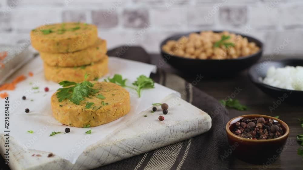 Raw veggie burger with chickpeas, vegetables and parsley leaves on kitechen countertop. Raw veggie burger with chickpeas, vegetables and parsley leaves on kitechen countertop.
