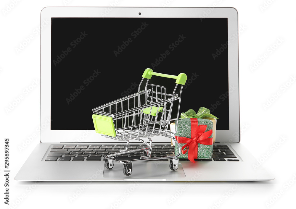Laptop and small cart with gift on white background. Internet shopping concept