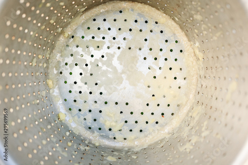 Bottom of stainless colander with dough.