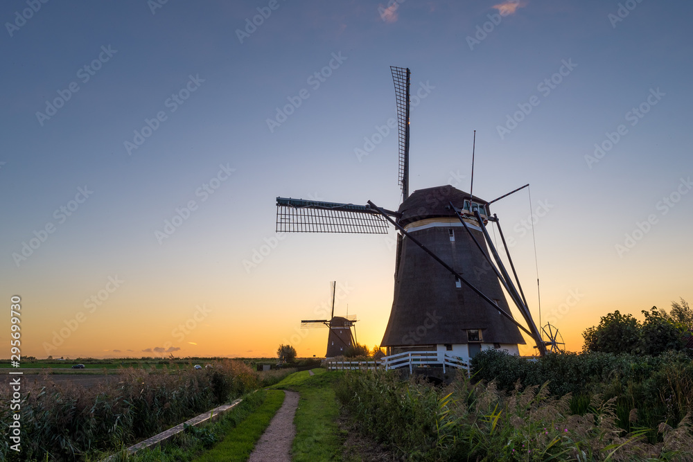 Traditional dutch windmills in a row with beautiful evening sky Traditional dutch windmills in a row with beautiful evening sky