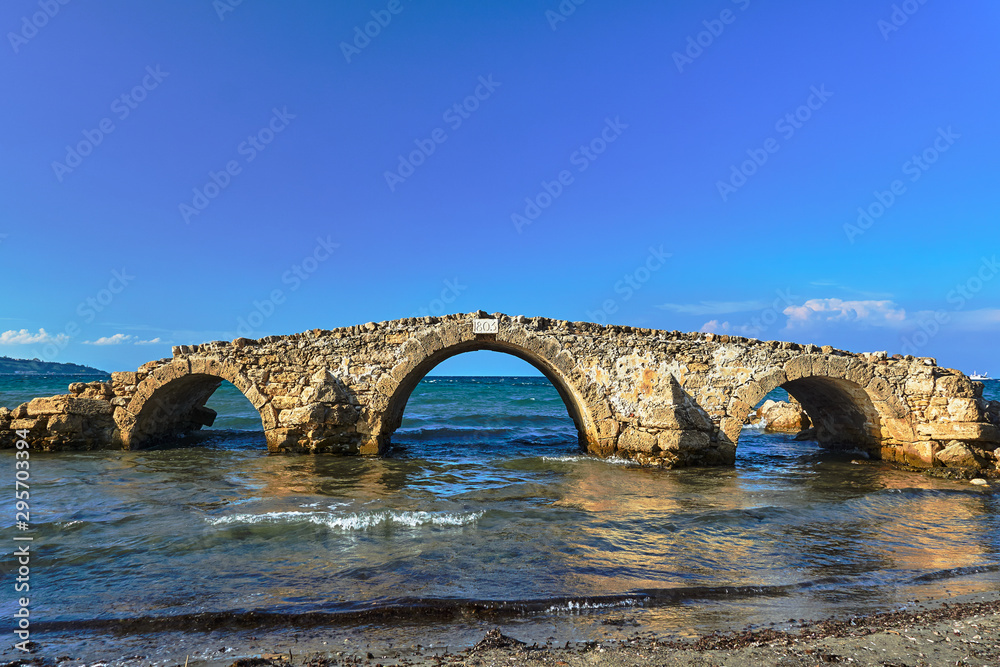 The ruins of a stone historic bridge on the coast of the island of Zakynthos in Greece..