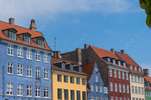 Scenic summer view of the ancient classic colorful houses with blue sky. Famous Nyhavn pier with colorful facades of old houses and vintage ships in Copenhagen, capital of Denmark