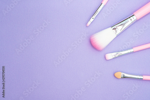 Makeup tools. Female fashion, makeup brushes on blue background. Flat composition, magazines, social media. Flat lay, top view, copy space.