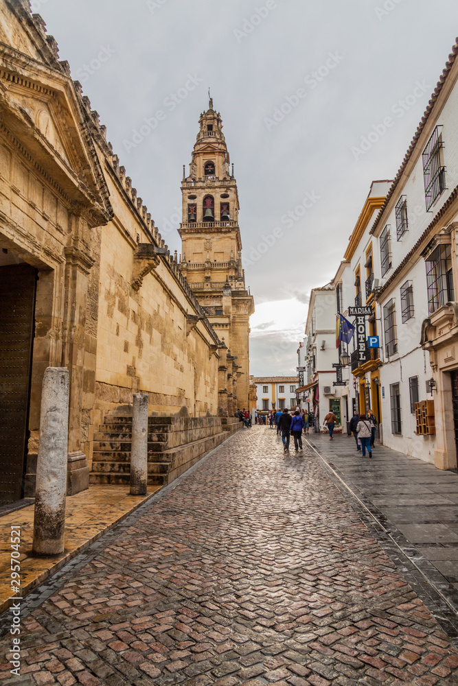 CORDOBA, SPAIN - NOVEMBER 4, 2017: Calle Cardenal Herrero street with the tower of Mosque-Cathedral in Cordoba.