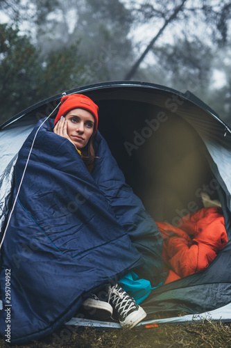 tourist traveler ralaxing in camp tent in foggy rain forest, closeup lonely hiker woman enjoy mist nature trip, green trekking tourism, rest vacation concept camping holiday, hiking campsite