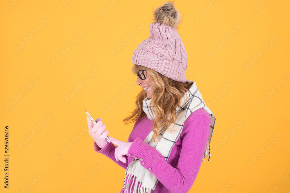 sheltered adult woman looking at mobile phone isolated on color background