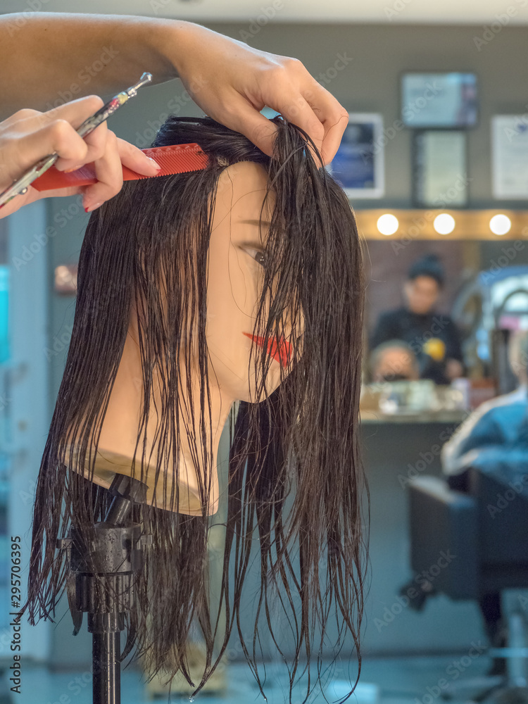 Naklejka premium Training hairdresser with mannequins.