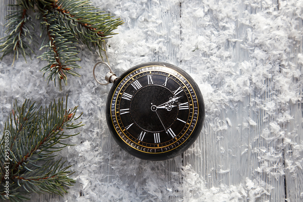 clock in the form of Christmas toys on a snowy background with spruce branches. The Concept Of Christmas.