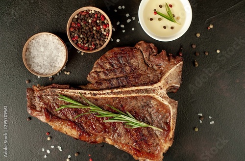 Grilled T-bone steak on a stone table. With rosemary and spices. 