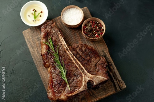 Grilled T-bone steak on a stone table. With rosemary and spices. 
