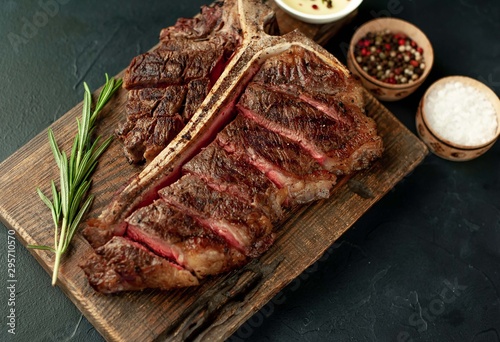 Grilled T-bone steak on a stone table. With rosemary and spices.