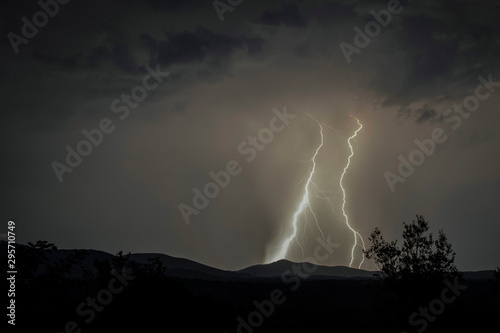 Lightning and moon in dramatic landscape