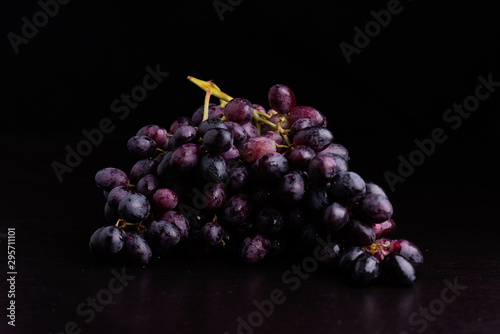 Blue wet Isabella grapes bunch isolated on black background as package design element