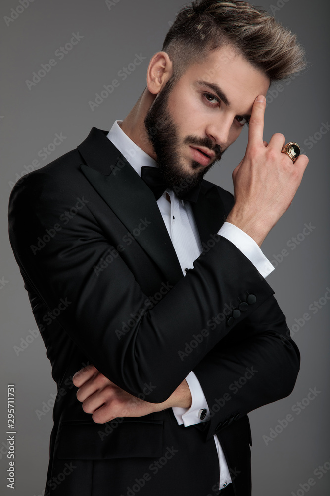 Thoughtful groom holding his finger on his forehead Thoughtful groom holding his finger on his forehead