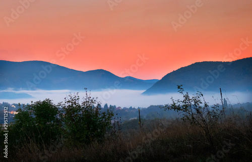 Sunrise with fog, mountains and town in the background. Drvar in Bosnia and Herzegovina.