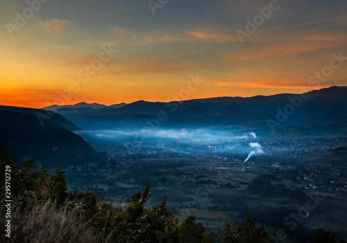 Sunrise with fog, mountains and town in the background. Drvar in Bosnia and Herzegovina.