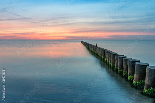 Baltic sea seascape at sunset, Poland, wooden breakwater and waves