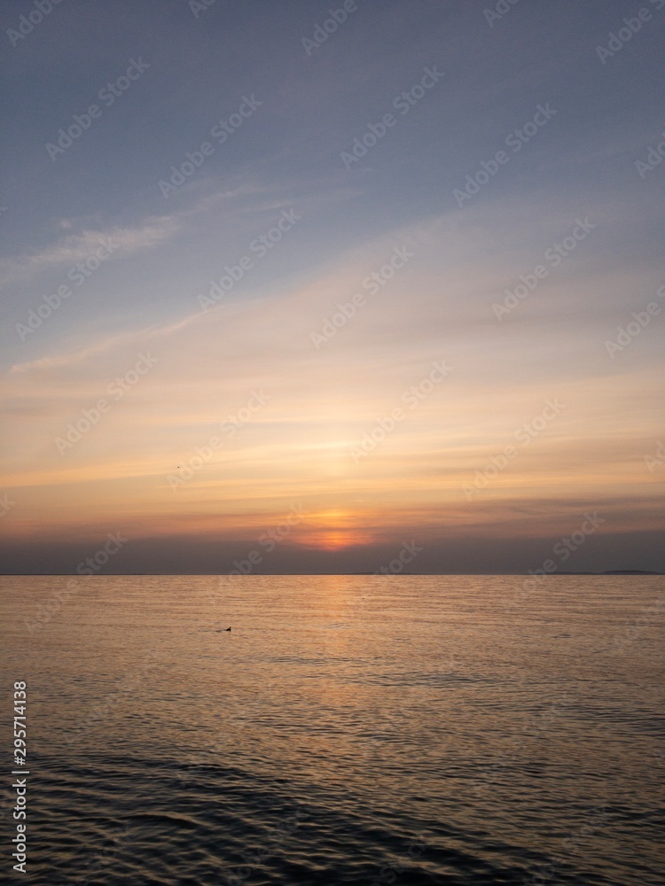 Serene seascape of Crimea. Sun descending into quiet sea