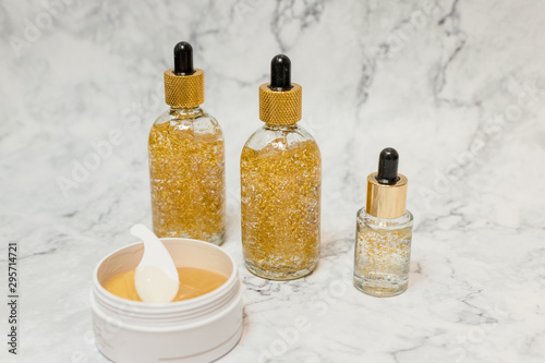 Collection of skincare spa products. Beauty concept.Bottles and jars with natural skincare cosmetics, creams and oils on marble background.Herbal dermatology cosmetic and Hydrogel golden cosmetic eye