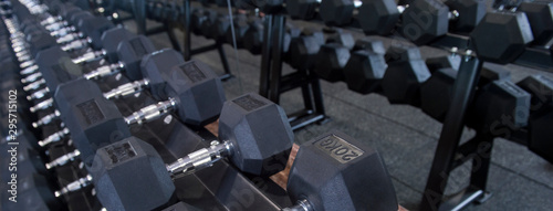 Close up many metal dumbbells on rack in sport fitness center