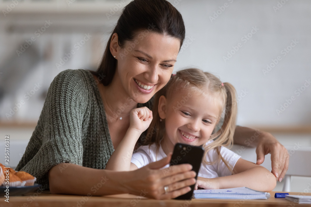 Smiling mother and little daughter taking selfie on phone Smiling mother and little daughter taking selfie on phone