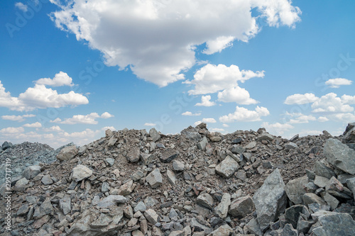 Gravel, pile of stones, on blue sky background. Top stone mountain